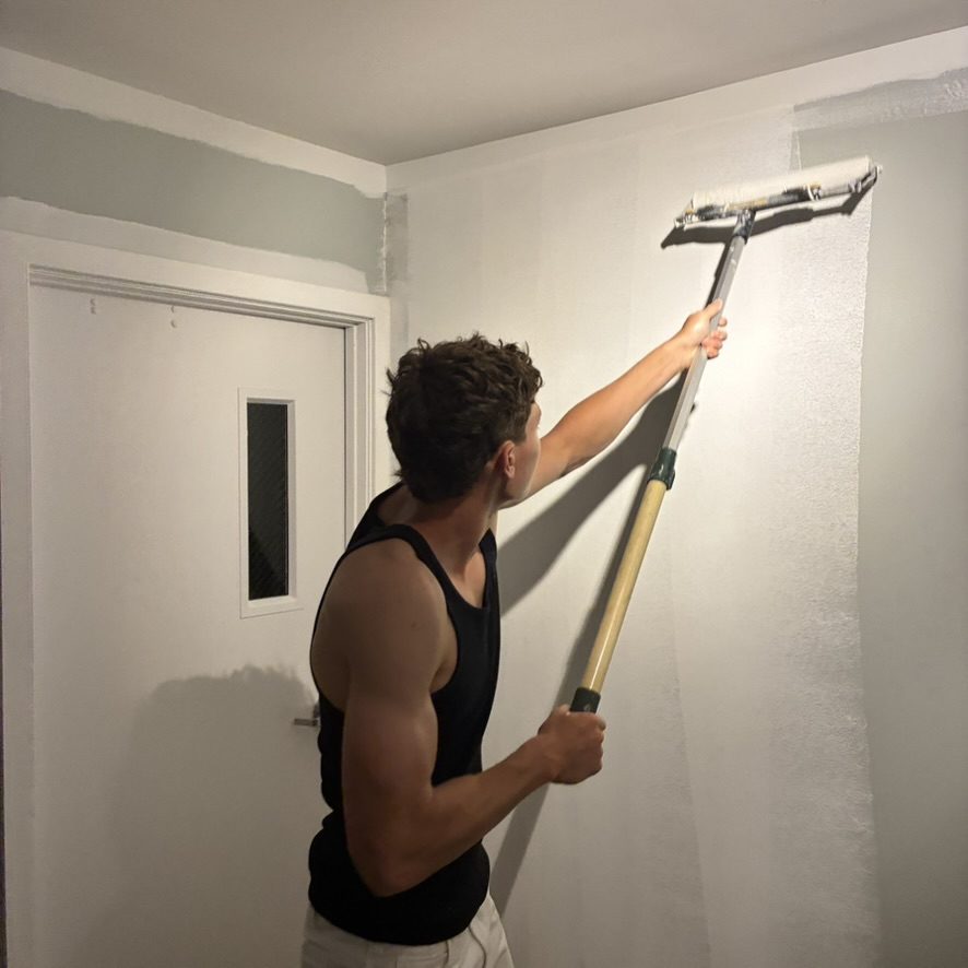 Painter rolling a fresh coat of paint onto an interior wall